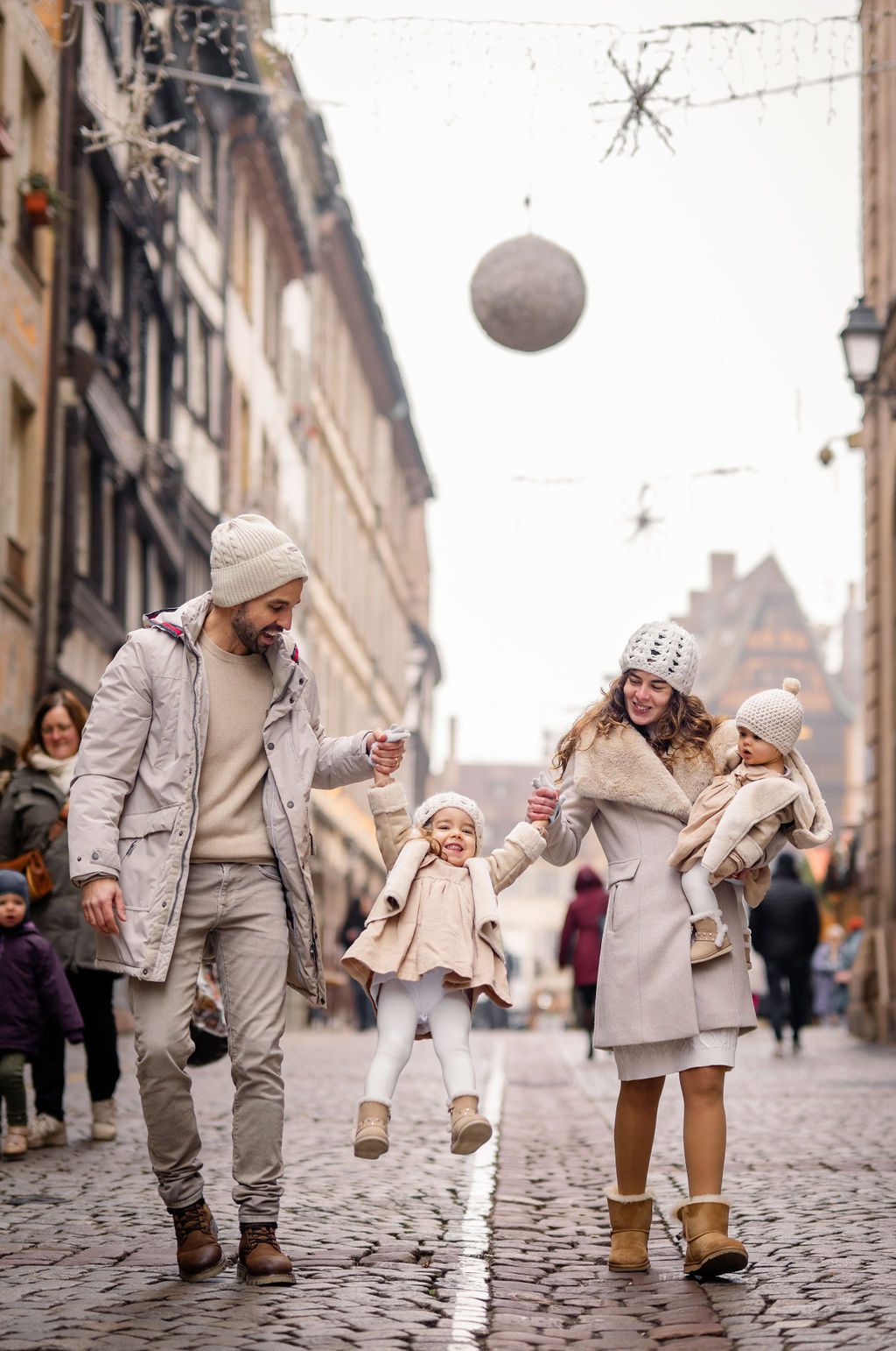 Kind hält Elternhände beim Weihnachtsmarkt Strasbourg
