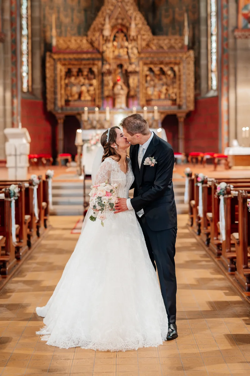 Sandra und Matthias küssen sich nach ihrer kirchlichen Trauung