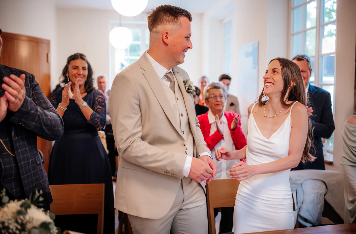 Braut und Bräutigam lachen miteinander während der Trauung