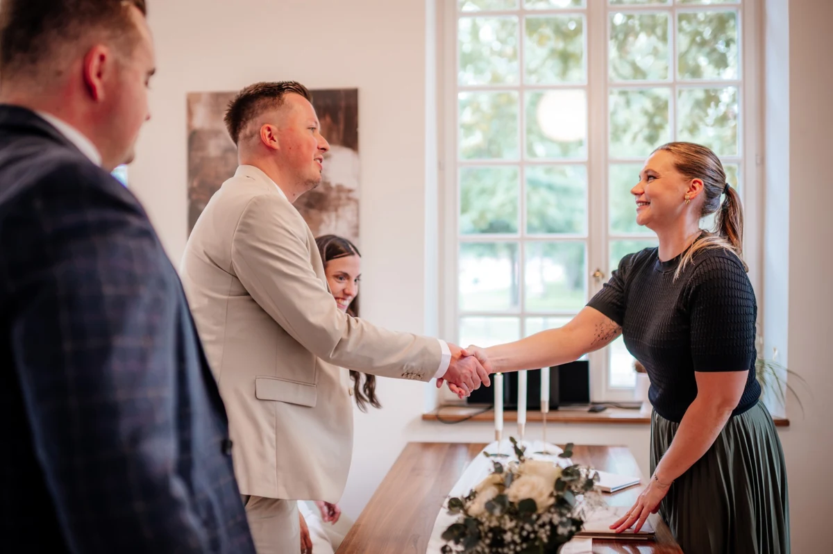 Die Standesbeamtin gratuliert dem frisch verheirateten Paar