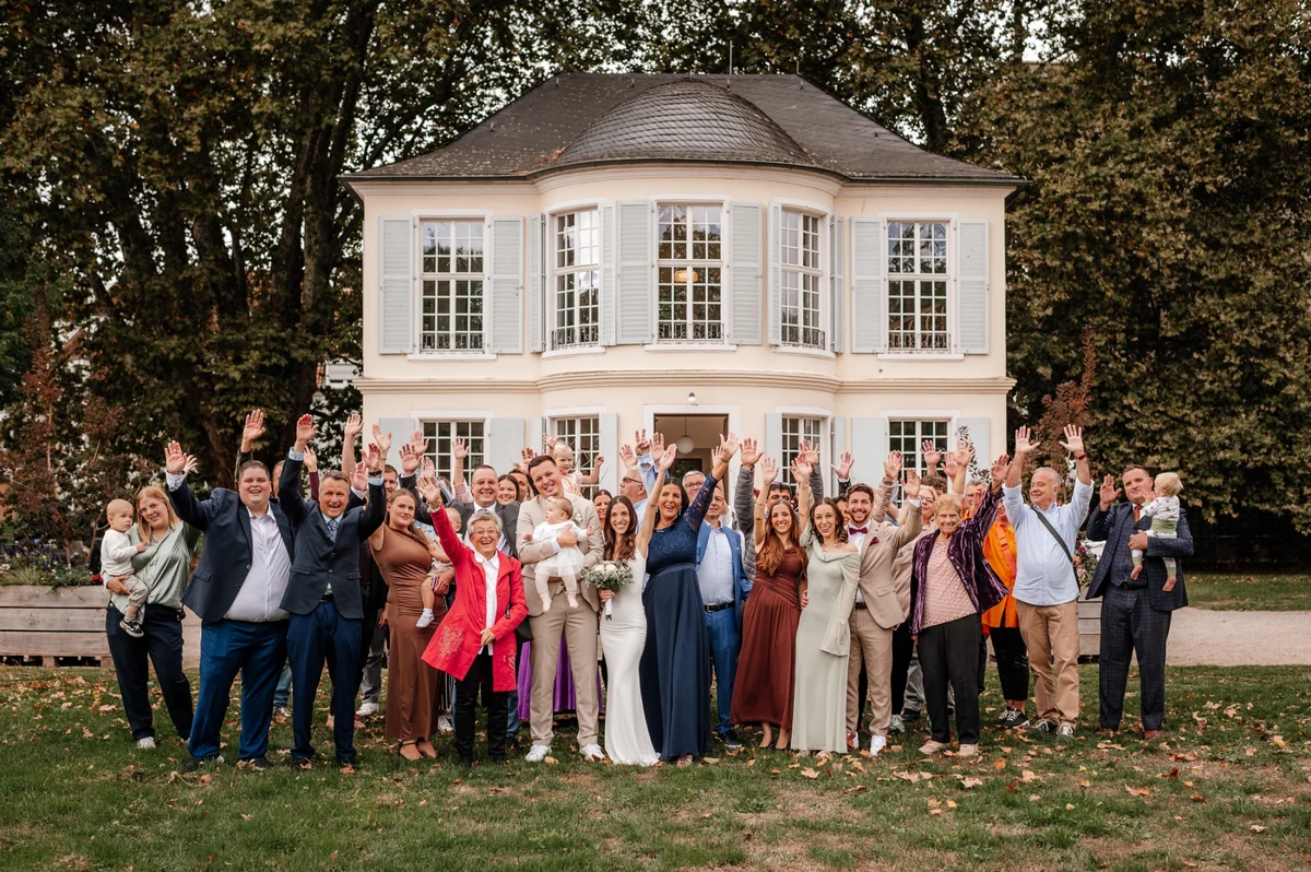 Gruppenfoto der Hochzeitsgesellschaft im Bürgerpark vor dem Schlösschen