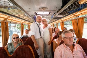 Ein Brautpaar und seine Gäste fahren gemeinsam in einem Oldtimer-Bus von der Innenstadt Freiburgs zur Hochzeitslocation.