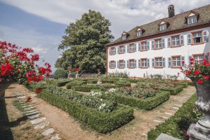 Ein Foto der Außenseite des Schlosses Burgeln in Schliengen, mit dem grünen Garten im Vordergrund - perfekt für eine romantische Hochzeit.