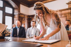Braut unterzeichnet das Heiratsregister im Rathaus Freiburg