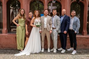 Brautpaar und Gäste posieren für ein Gruppenfoto in Freiburg